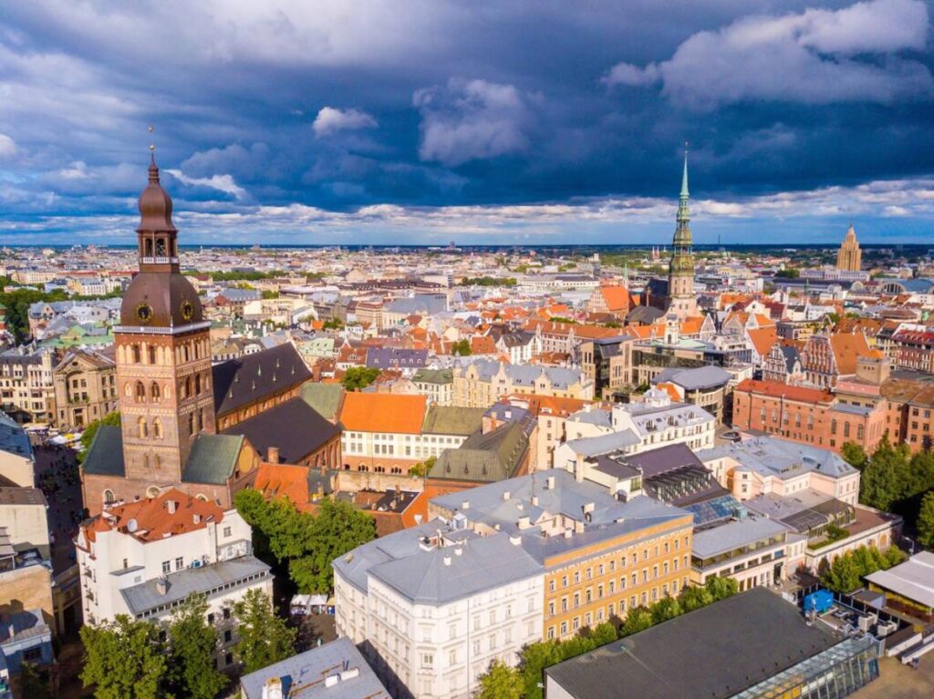 Aerial view of a European city with historic buildings and a dramatic cloudy sky.