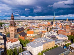 Aerial view of a European city with historic buildings and a dramatic cloudy sky.