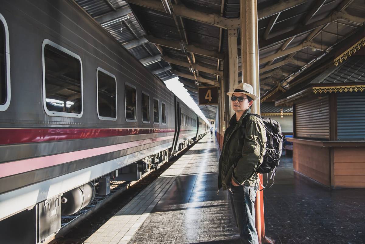 A traveller with a backpack standing beside a train on platform 4.