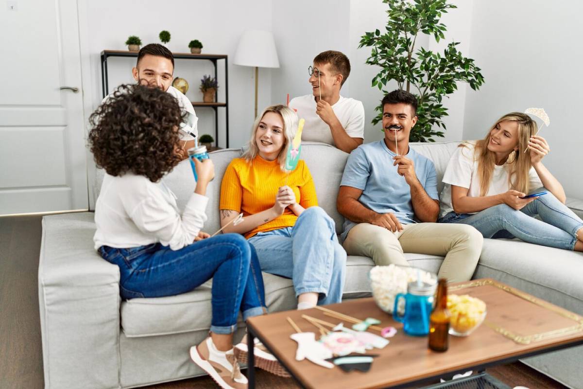 Group of young adults enjoying a playful game in a cozy living room.
